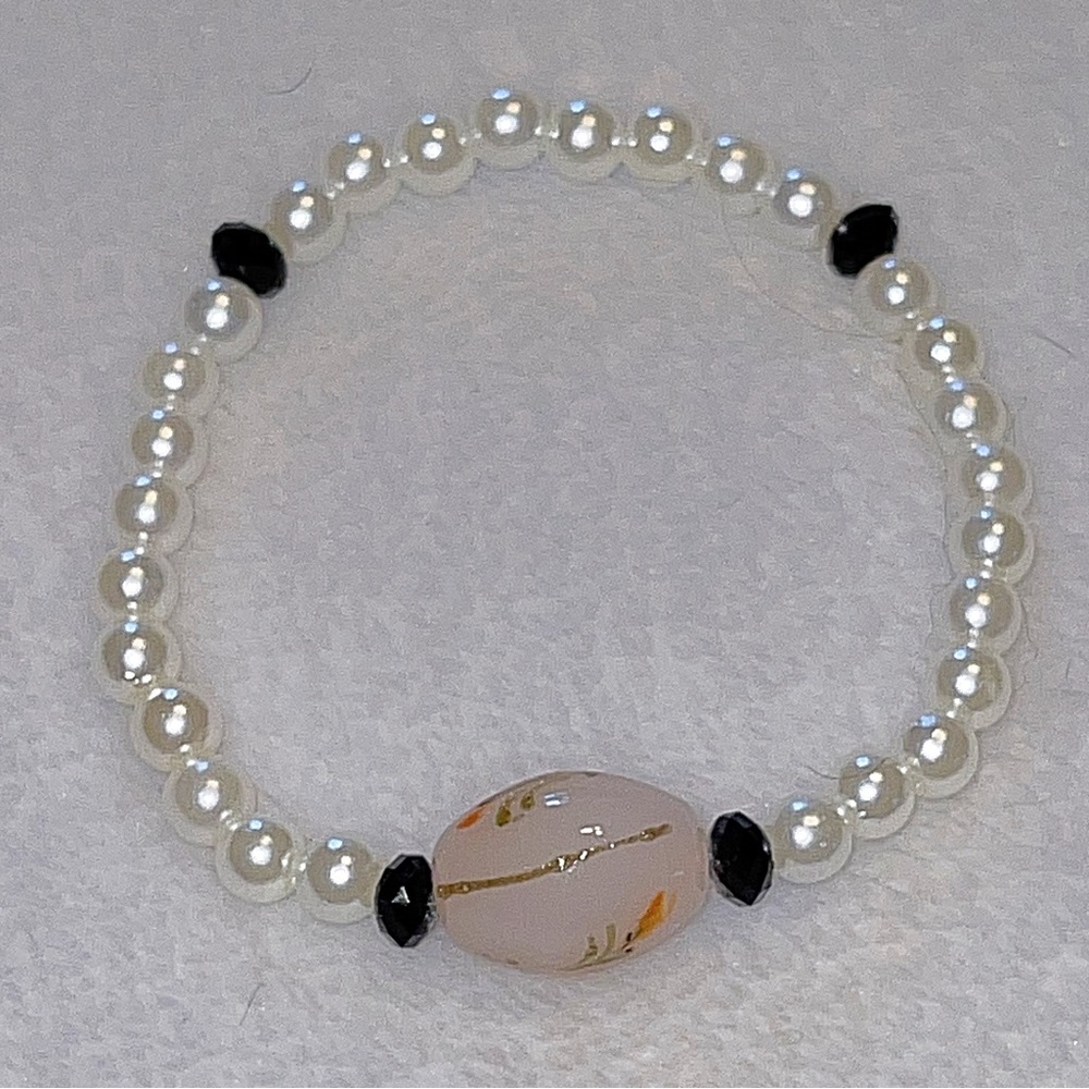 Nice bracelet. Handmade, nice center surrounded by pearl beads on both sides.